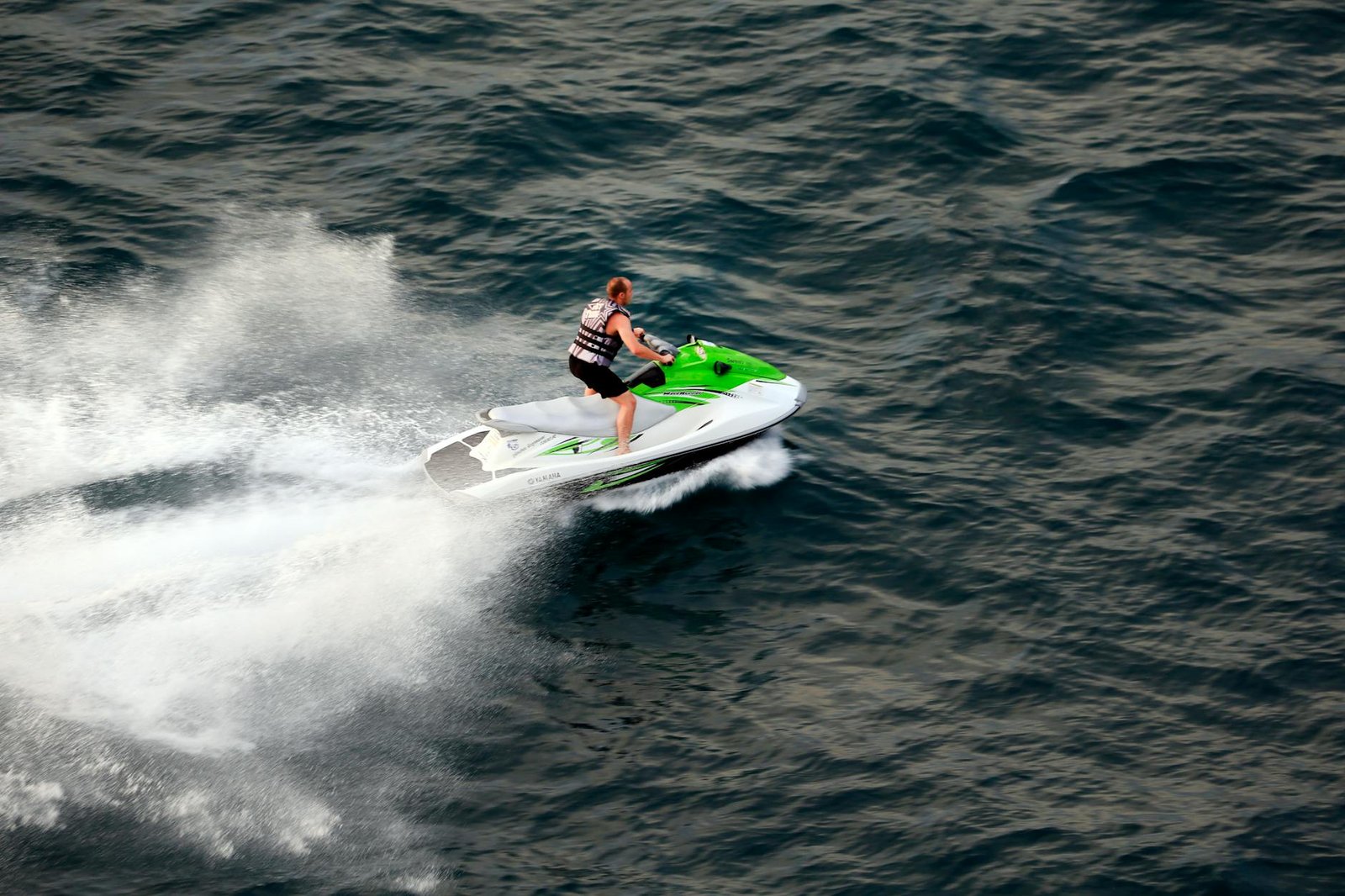 man riding jet ski on ocean waters at speed