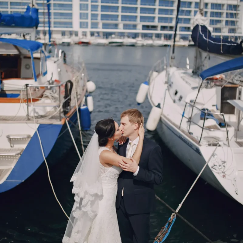 Alquiler de barco para eventos en Málaga, Pareja de recién casados besándose en un yate en el puerto de Málaga, perfecto para bodas y celebraciones románticas