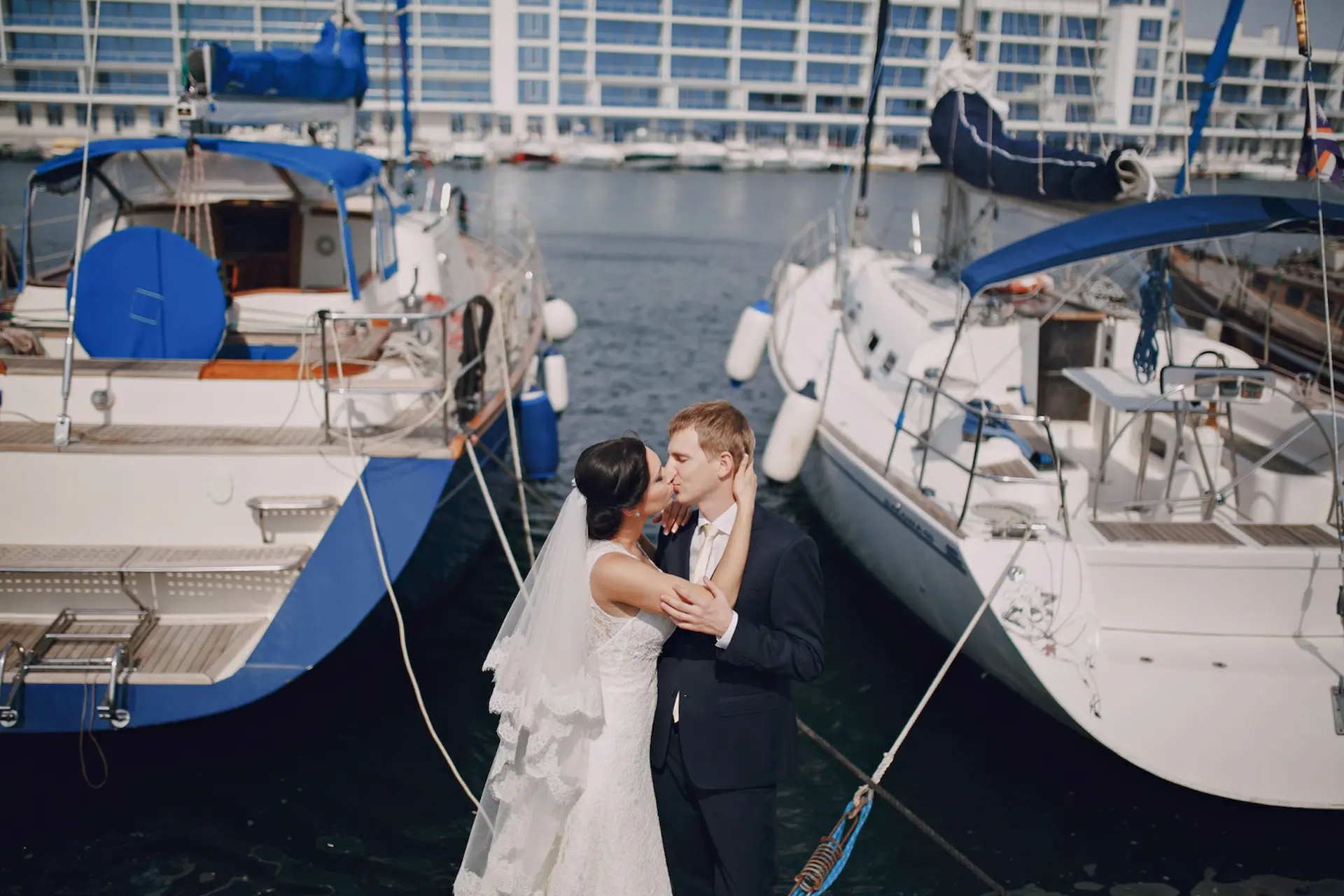Alquiler de barco para eventos en Málaga, Pareja de recién casados besándose en un yate en el puerto de Málaga, perfecto para bodas y celebraciones románticas
