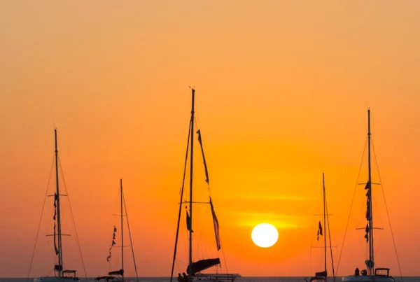 Yate navegando al atardecer para comparar yate catamarán o velero en Costa del Sol