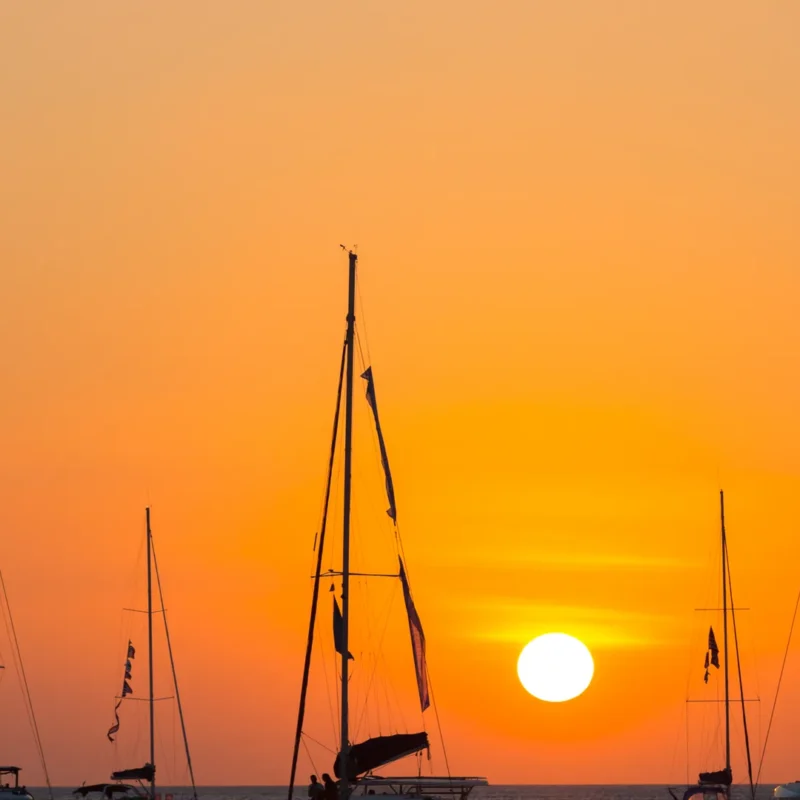 Yate navegando al atardecer para comparar yate catamarán o velero en Costa del Sol